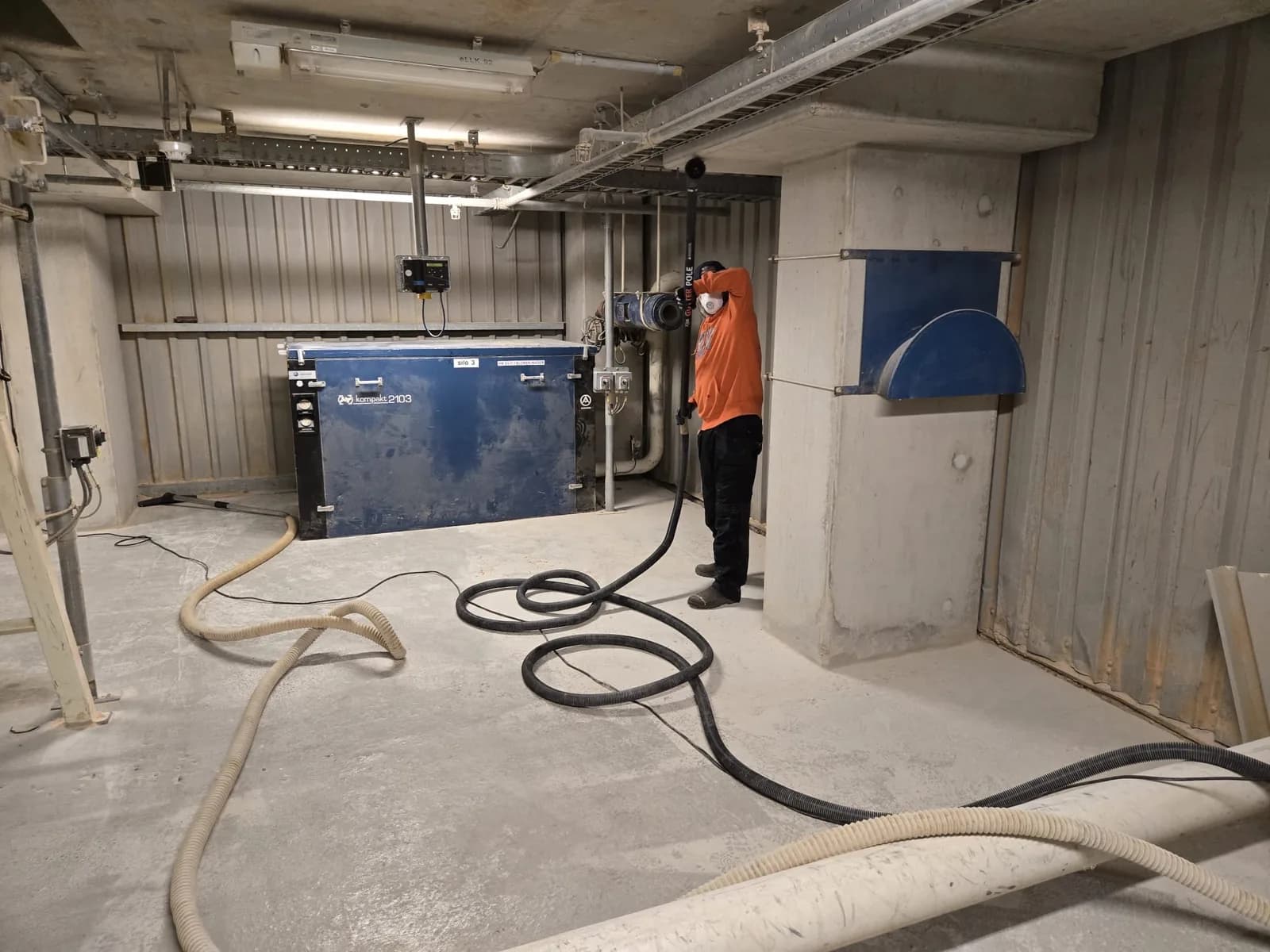 Medewerker reinigt de vloer van een industriële bedrijfshal